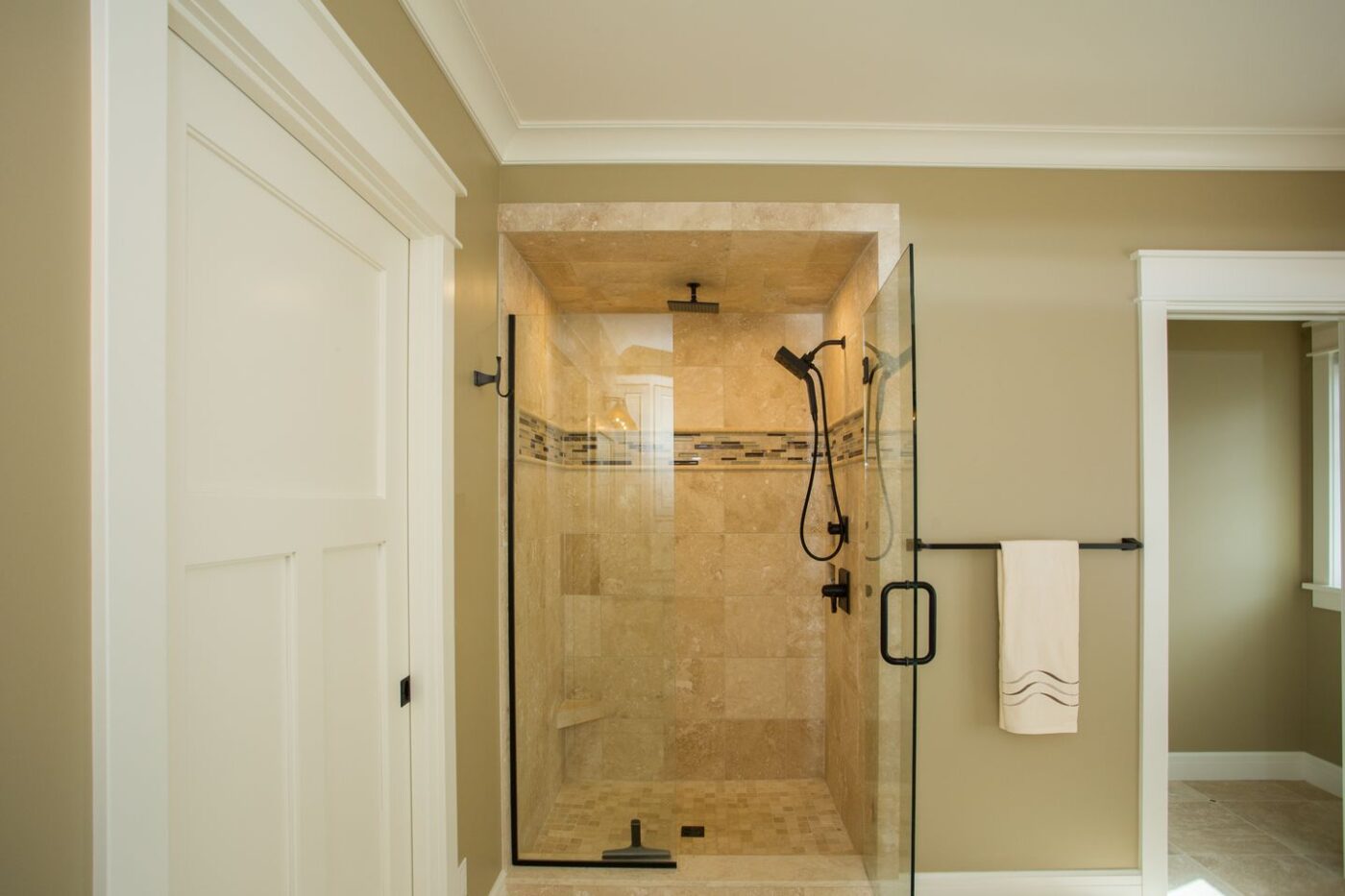 Tiled shower with black accents around the glass