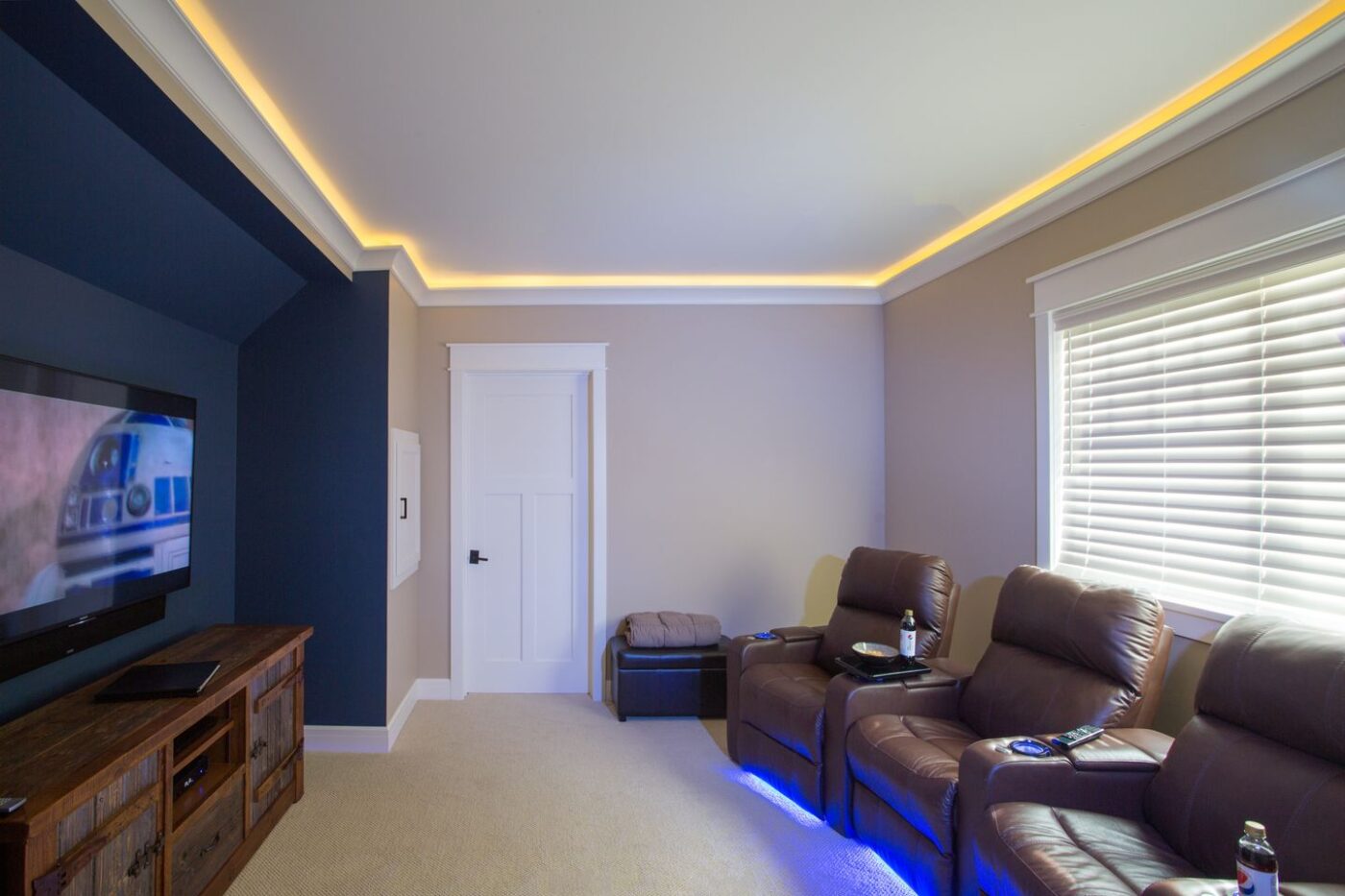 Movie room with crown lighting and under chair glow