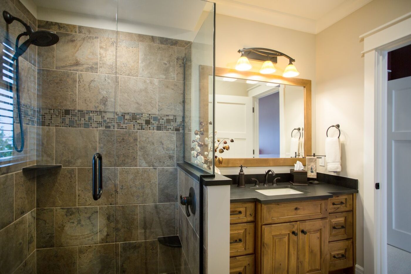 Tiled shower upstairs in bath with custom cabinets